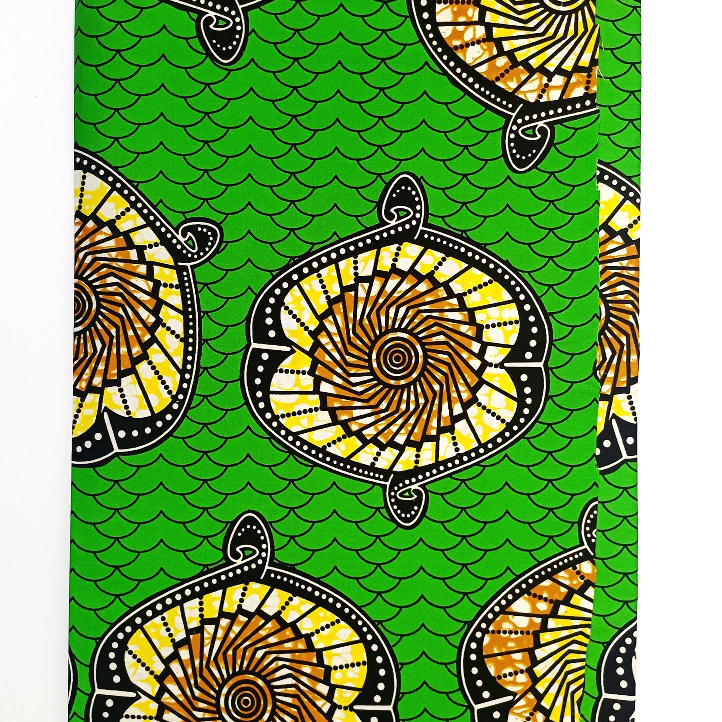 Traditional patterned fabric with yellow and black designs on a green background