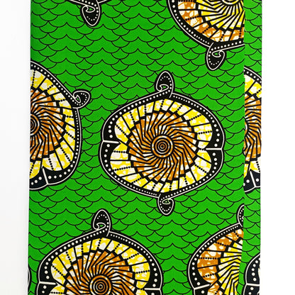 Traditional patterned fabric with yellow and black designs on a green background