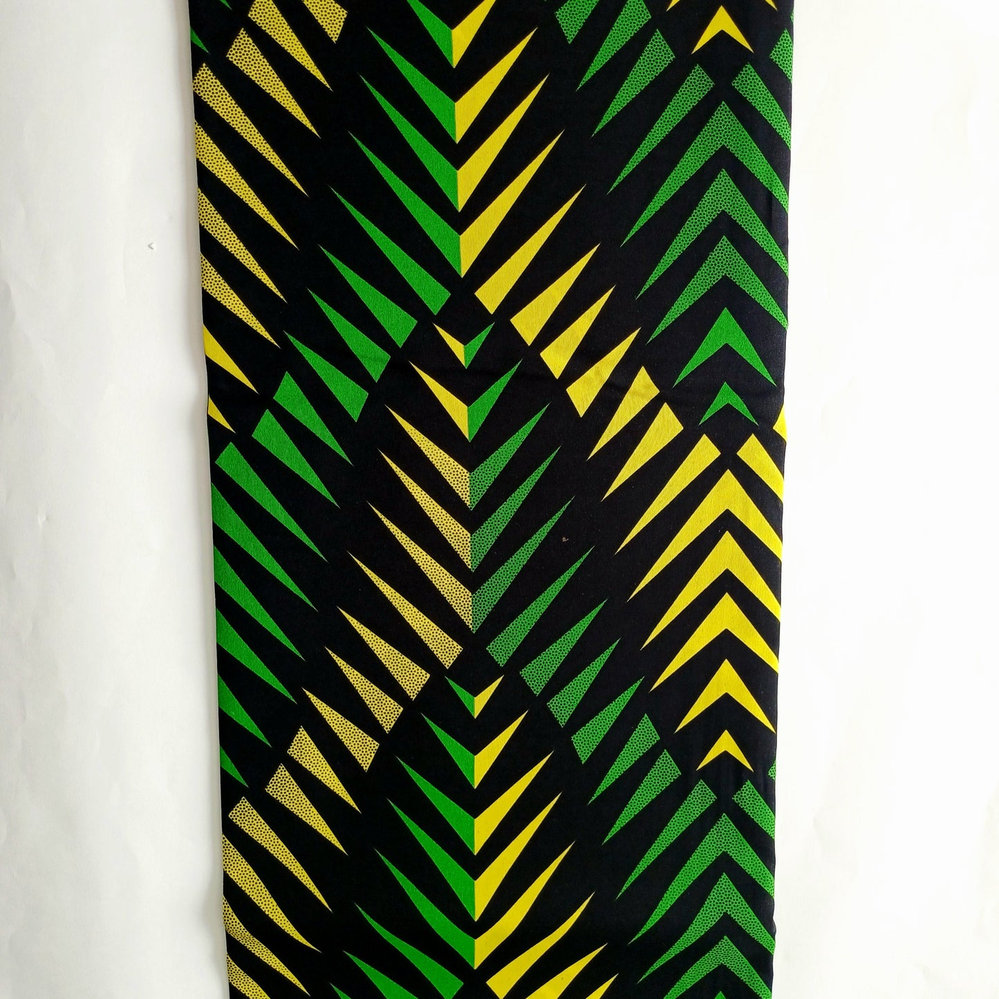A vertical rectangular fabric featuring a bold geometric chevron pattern in black, green, and yellow, displayed against a plain white background.