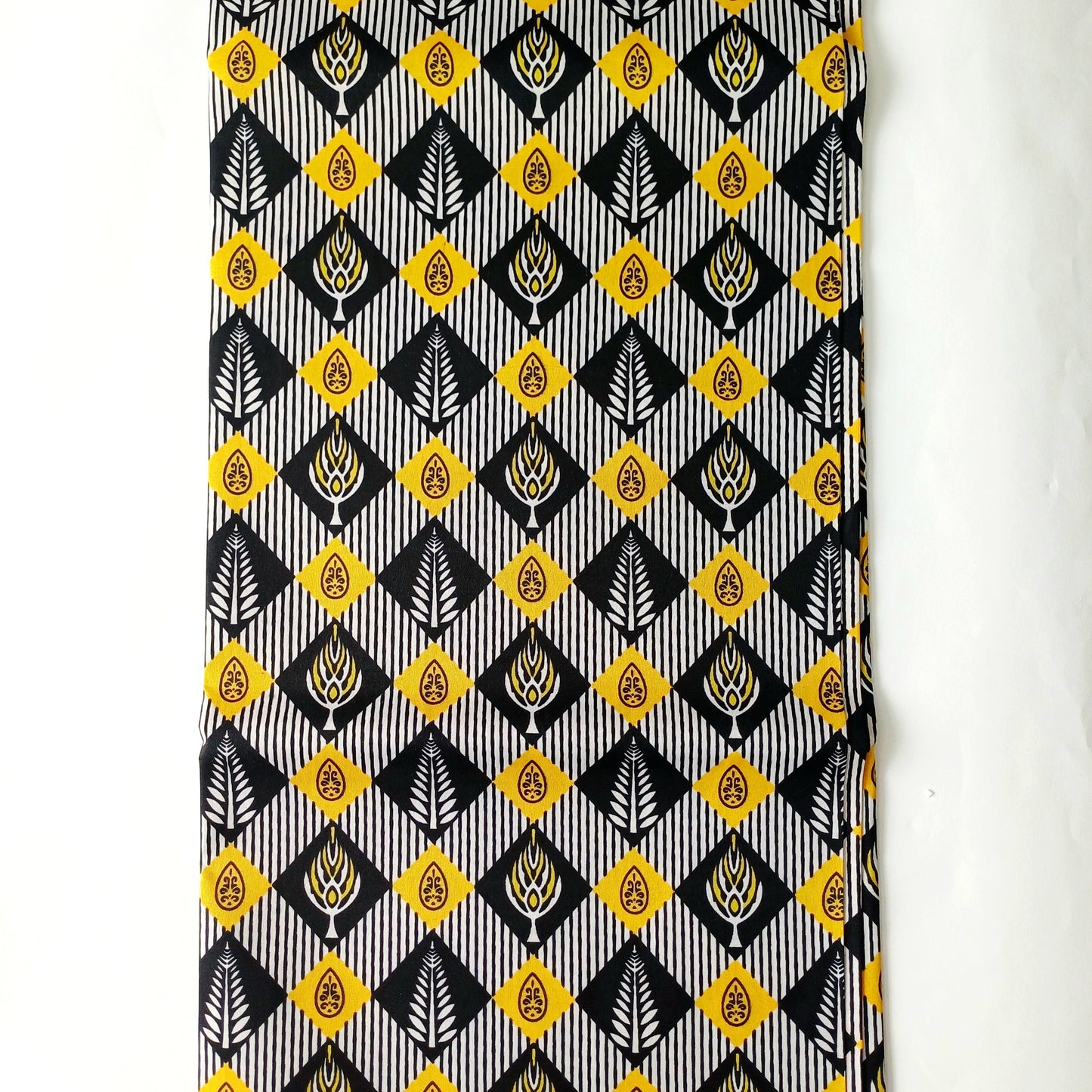 A close-up of a patterned fabric or featuring a repeating geometric design in black, white, yellow, and grey.