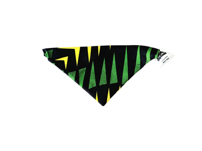 A triangular pet bandana with a black, green, and yellow geometric pattern, laid flat on a white background.