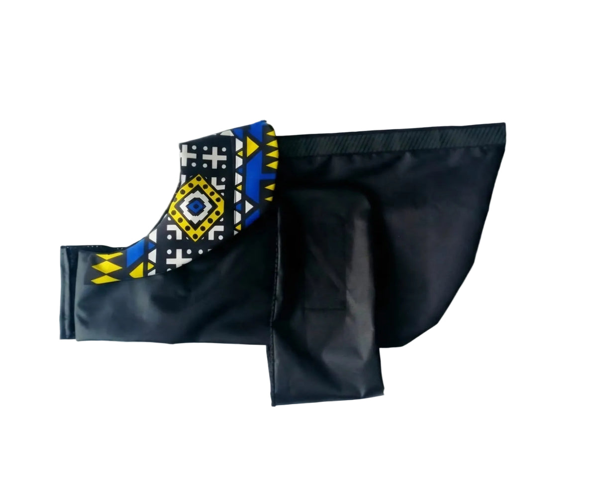 Black dog cot with a Blue, Yellow and White patterned collar