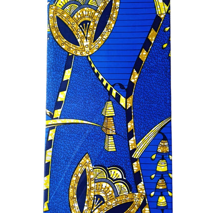 A close-up of a blue and gold patterned fabric, featuring geometric and floral motifs.